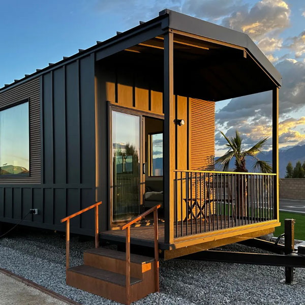 tiny home with a porch at sunset